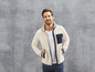 Mann in einer weißen Fleecejacke mit blauen Details.