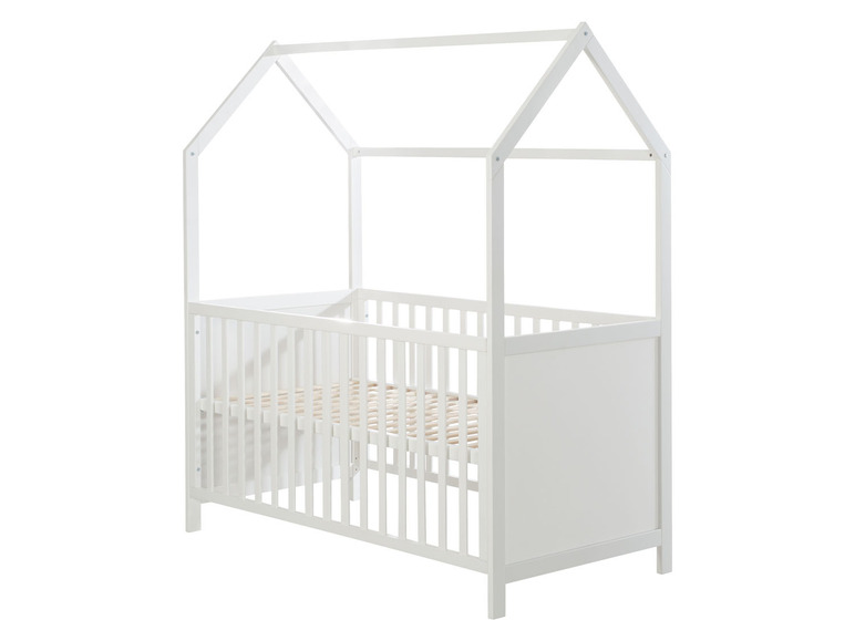 Ein weißes Holzbabybett mit einem Dach in Hausform.