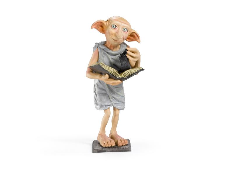 Dobby-Figur aus der NIKE-Reihe Magische Kreaturen, die ein offenes Buch hält.