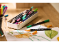 Bunte Dual-Tip-Marker und Zeichnungen auf einem Holztisch.