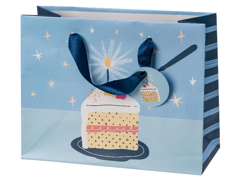 Blaue Geschenktüte mit Geburtstagstorte, Kerzen und Sternen, mit Cupcake-Geschenkanhänger.