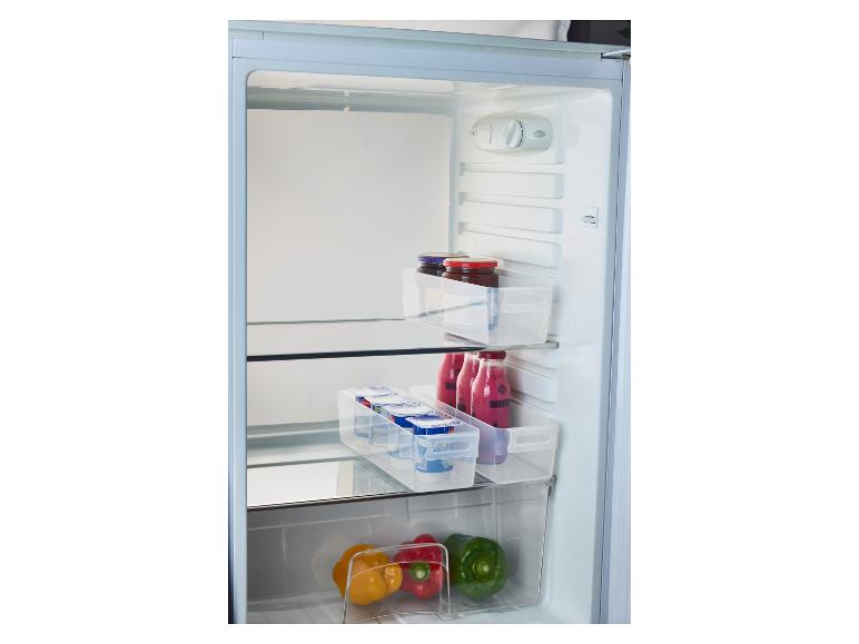 Kühlschrankinnenraum mit Marmeladengläsern, Joghurts, Smoothies und Paprika in transparenten Behältern.