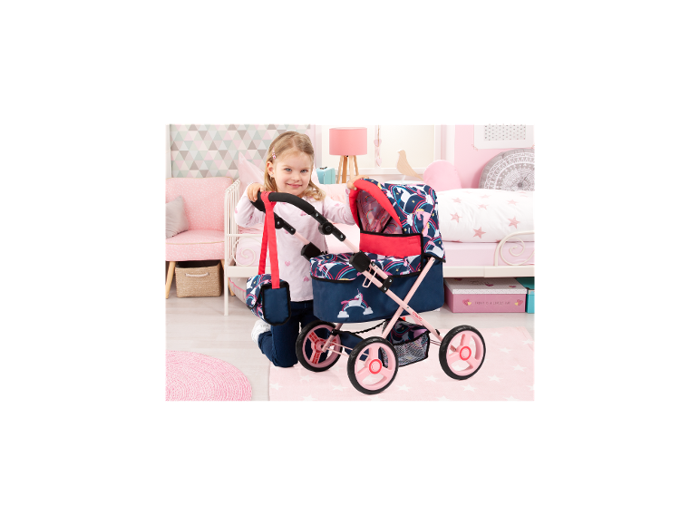 Mädchen mit BAYER DESIGN Puppenwagen Trendy Unicorn Cosatto in einem Kinderzimmer.