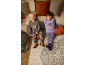 Zwei lächelnde Kinder in Halloween-Pyjamas, auf einem Teppich neben einem Sofa sitzend.