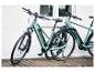 Zwei hellblaue E-Bikes mit schwarzen Akzenten auf einer Holzterrasse geparkt.