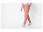 Eine Person in rosa Jogginghose und rosa Strickjacke.