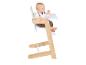 Baby sitzt in einem Holz- und weißen Hochstuhl mit Tablett.