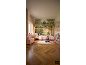 Kinderzimmer mit Hausbett, Waldtapete und lesendem Mädchen.