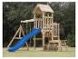 Holzspielplatz mit blauer Rutsche, Schaukeln und Picknicktisch auf einer Wiese.