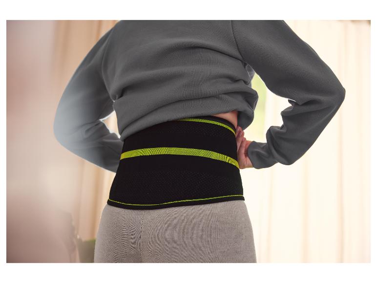 Eine Frau trägt einen Lendenwirbelstützgürtel.