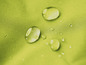 Wassertropfen auf einem hellgrünen, wasserdichten Stoff.