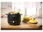 Slow Cooker mit gewürfeltem Gemüse und frischen Zutaten auf einem Holztisch.