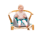 Baby in einem Hochstuhl mit Sicherheitsgurt.