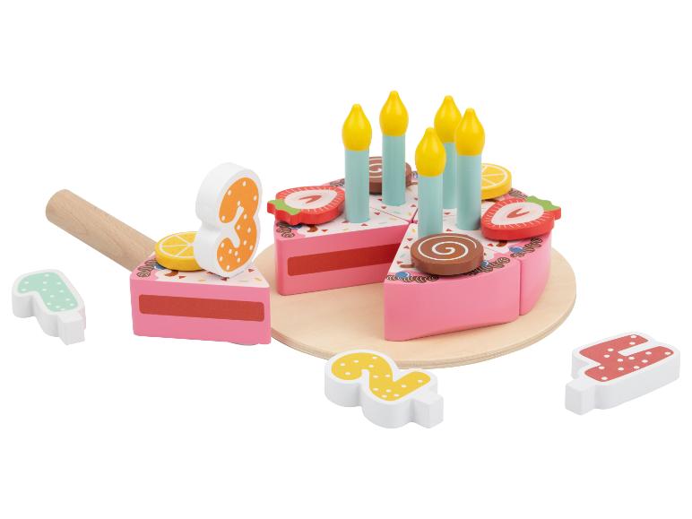 Hölzerner Spielzeug-Geburtstagskuchen mit Kerzen, Fruchtbelägen und den Zahlen 1, 2, 3, 4.