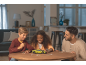 Kinder und ein Mann setzen am Tisch ein grünes 3D-Puzzle eines Sportwagens zusammen.