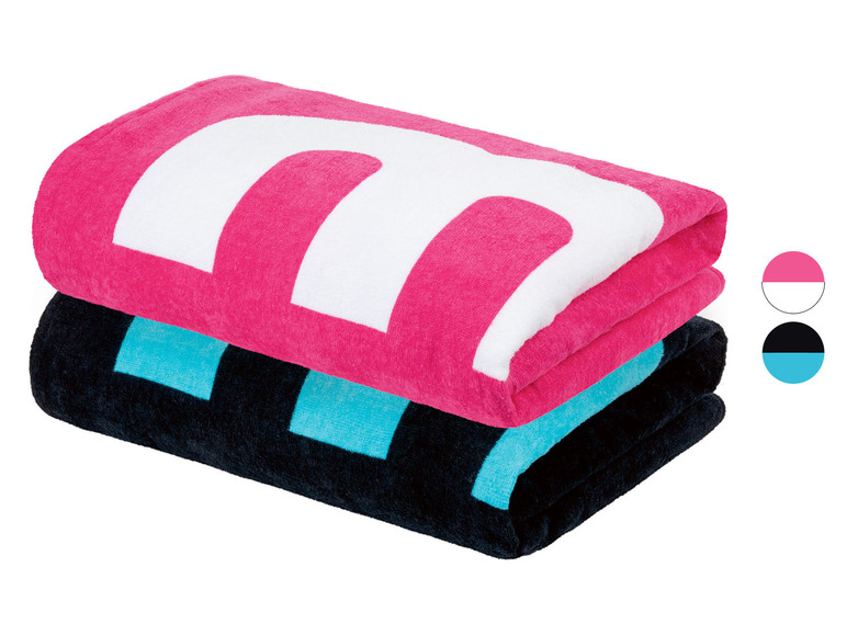 Zwei Strandtücher, eines pink mit einem weißen 'M' und eines schwarz mit türkisfarbenen Blöcken.