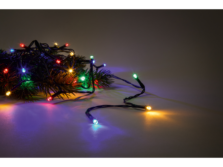 Bunte Weihnachtsbeleuchtung auf Tannenzweigen, die eine festliche Stimmung erzeugt.
