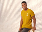 Mann in einem gelben T-Shirt mit Palmen-Print.