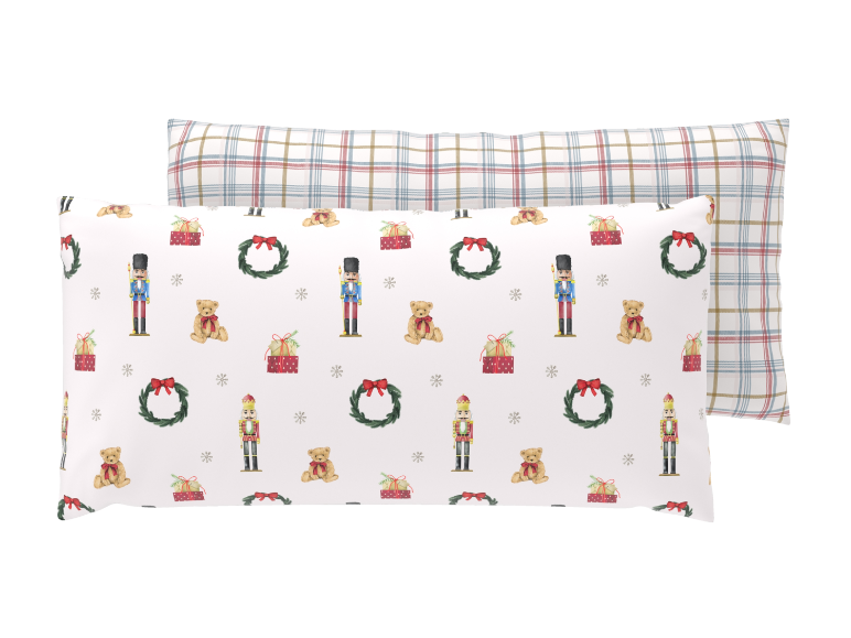 Zwei Kissenbezüge mit weihnachtlichem Nussknacker- und Karomuster.