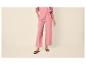 Damen-Hose in Rosa mit weitem Bein und schwarzen flachen Sandalen.