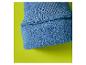 Detail eines blauen Pulloverbündchens mit Fleecefutter auf limettengrünem Hintergrund.