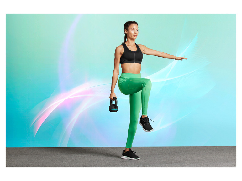 Eine Frau in Sportkleidung hält eine Kettlebell während eines Workouts.