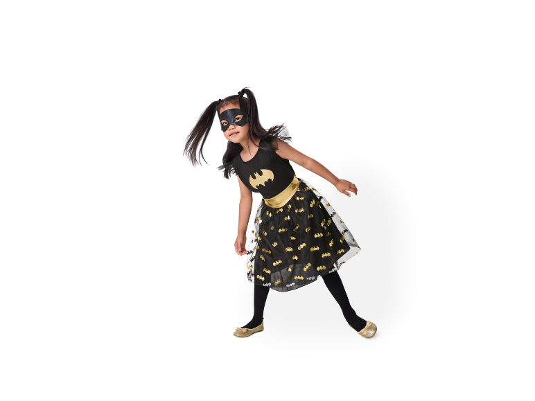 Mädchen in schwarzem Batman-Kleid mit goldenen Schuhen.