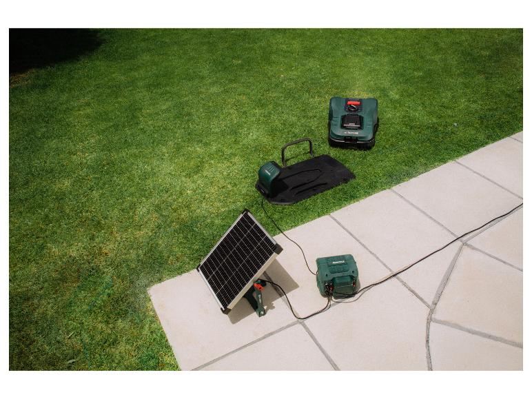 Mähroboter und Ladestation mit Solarpanel auf Rasen und Terrasse.