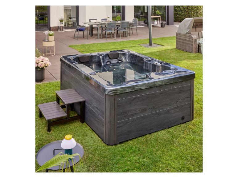 HOME DELUXE Outdoor-Whirlpool Black Marble auf einer Rasenfläche neben der Terrasse.