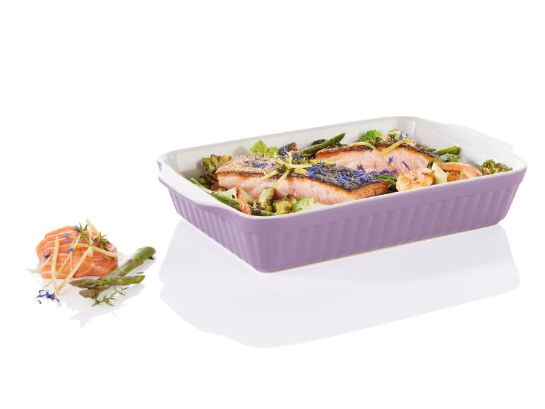 Gegrillter Lachs mit Spargel und Brokkoli in einer violetten Auflaufform.