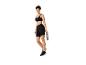 Frau in schwarzer Sportkleidung mit Stirnband, Sport-BH, Radlerhose und Wasserflasche.