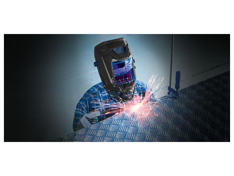 Schweißer mit Schutzmaske und Handschuhen schweißt eine Metallplatte.