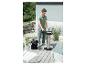 Mann reinigt Grill mit Aschesauger auf einer Terrasse.