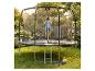 Kind springt auf einem Gartentrampolin mit Sicherheitsnetz, mit Ball und Schuhen auf dem Rasen.