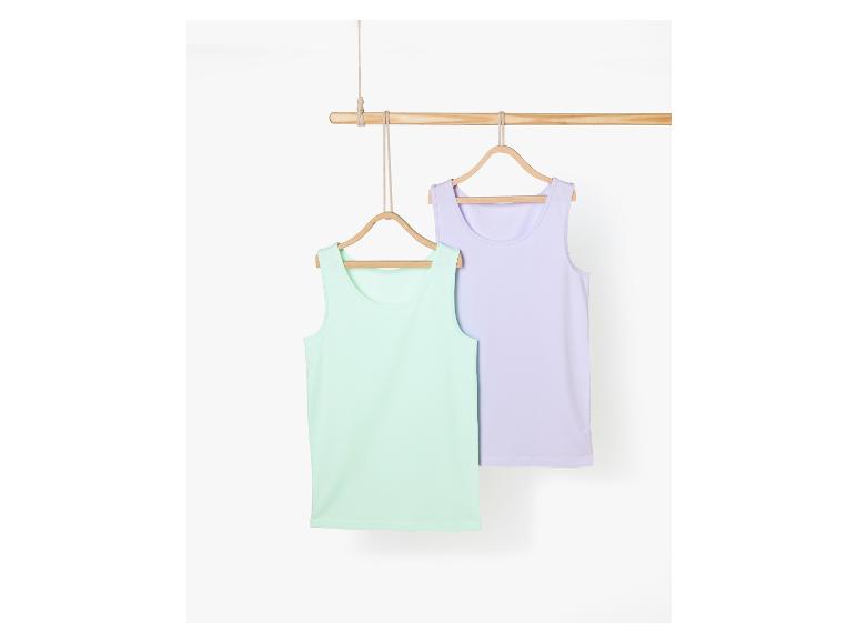 Zwei einfache Tanktops, eines hellgrün und eines lila, hängen an einem Holzaufhänger.