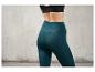 Eine Frau trägt dunkelgrüne Leggings.