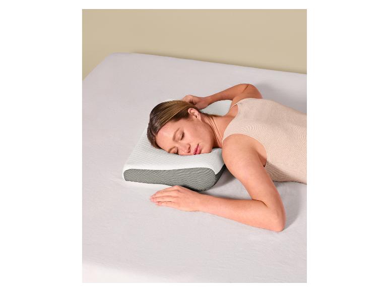 Frau schläft auf einem weißen und grauen ergonomischen Kissen auf einem Bett mit weißen Laken.