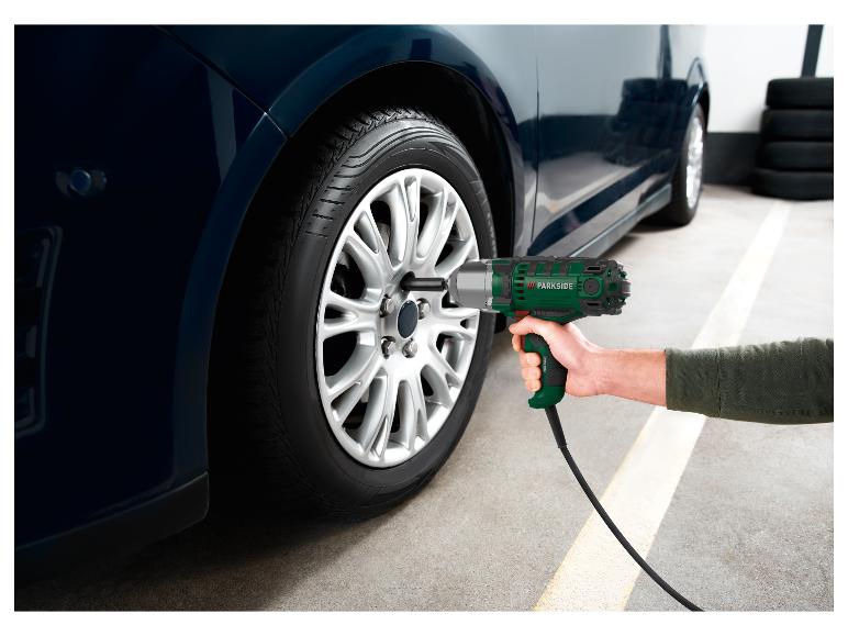 Eine Person benutzt einen Parkside Schlagschrauber, um ein Autorad zu wechseln.