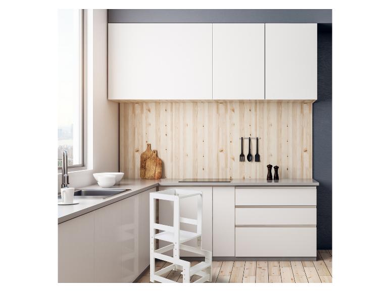 Moderne Küche mit weißen Schränken, grauer Arbeitsplatte, Lernturm und Küchenutensilien.