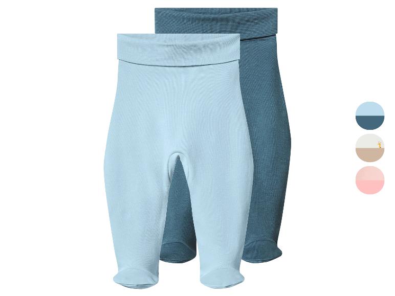 Zwei blaue und dunkelblaue Babyhosen mit Füßen, mit Farbmustern.