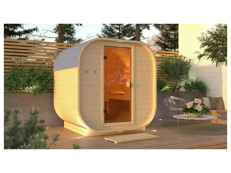 Außensauna mit Holzverkleidung und Glastür auf einer Terrasse mit Sitzbereich.