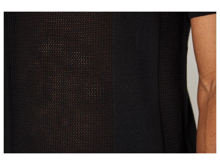Detail eines schwarzen Shirts aus durchbrochen gestricktem Stoff.