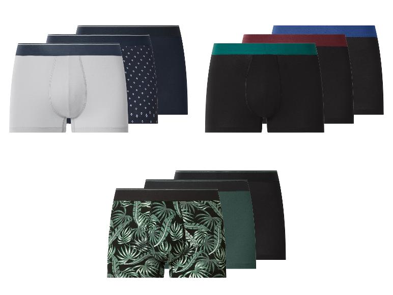 Herren-Boxershorts in verschiedenen Farben und Mustern, darunter Weiß, Schwarz, mit geometrischen und Blattmustern.