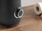 Schwarzer Mixer mit Drehregler und einer Rolle Küchenpapier auf einem Holztisch.