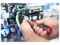 Hände reparieren ein elektronisches Gerät mit einem Schraubendreher