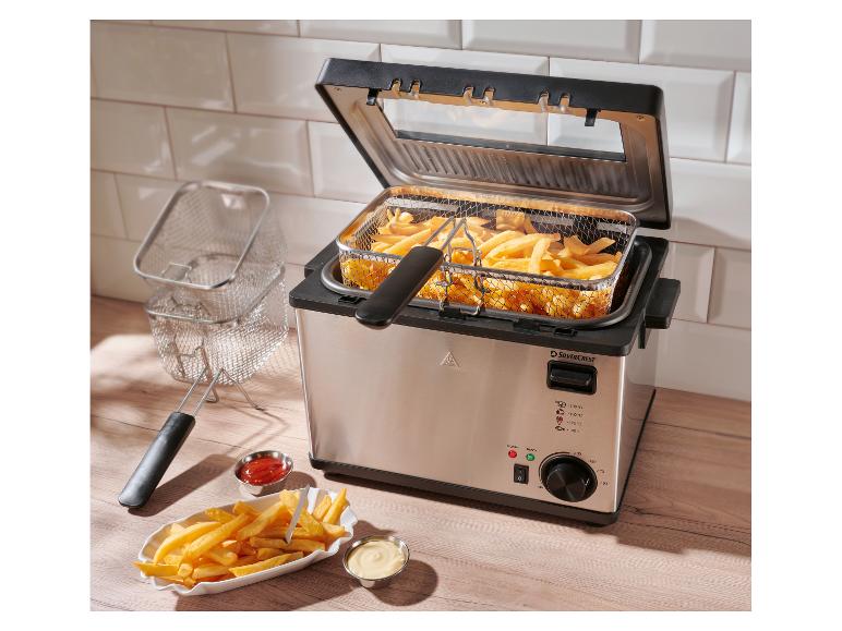 SilverCrest Fritteuse mit Pommes Frites und Saucen auf Holzplatte