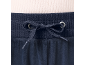 Nahaufnahme einer marineblauen Velours-Jogginghose mit Kordelzug und hellem Rippoberteil.
