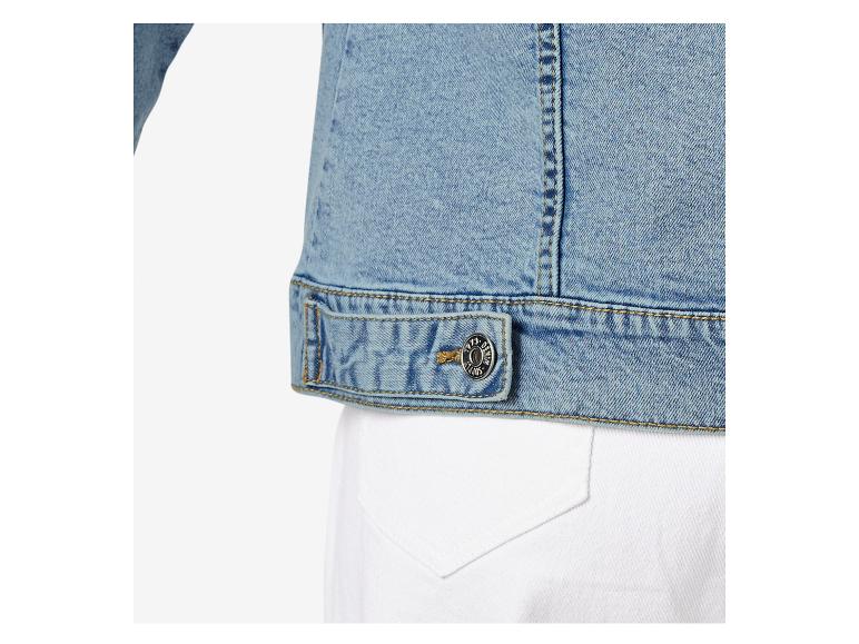 Nahaufnahme einer hellblauen Jeansjacke mit Metallknopf und gelben Nähten.