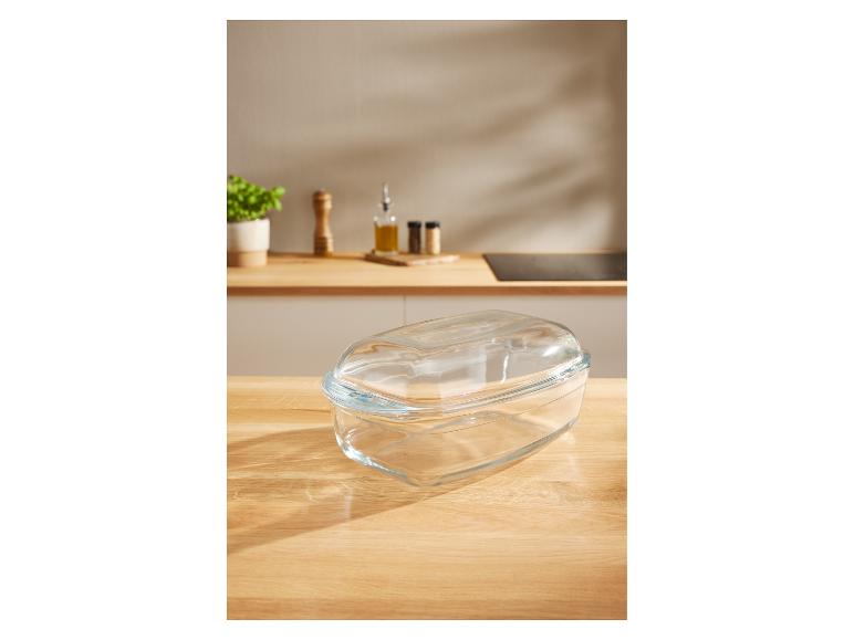 Glasauflaufform mit Deckel auf einer Küchenarbeitsplatte mit Gewürzen und einer Pflanze.