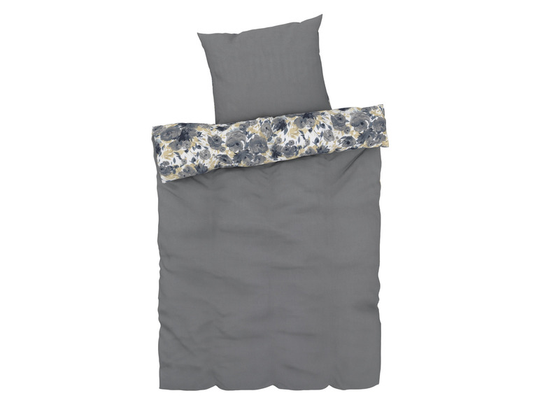 Ein grauer Bettbezug mit einem Kissenbezug mit Blumenmuster.